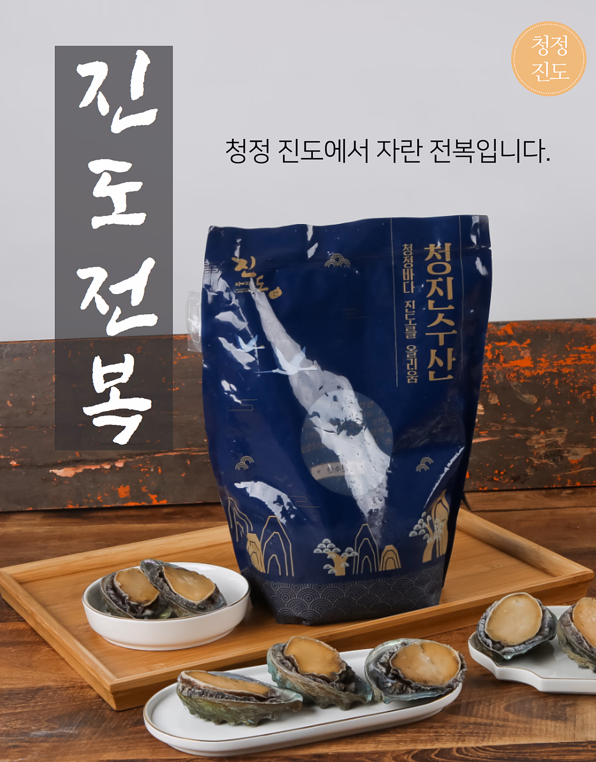청진수산 진도전복 패키지와 실물 전복, 나무 트레이 위 촬영 구성