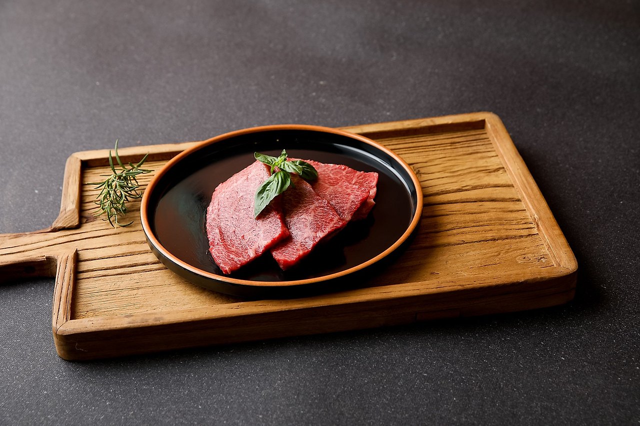 검은 접시 위 한우, 나무 도마, 허브