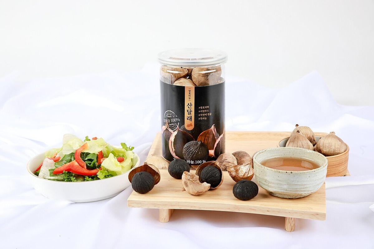 산달래 흑마늘 라이프스타일 컷 — 흰 접시에 흑마늘 알, 로즈마리 허브, 서리 낀 유리컵